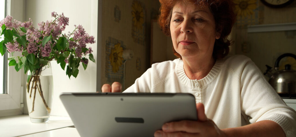 Woman sitting on a table reading a tablet